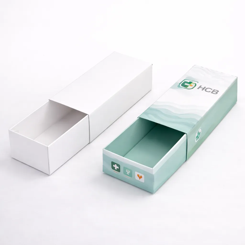 Two sliding drawer-style boxes, one plain and one printed with teal wave patterns and HCB branding. class=